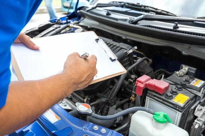 Image of a mechanic checking things off a list.
